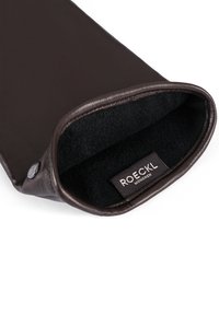 Dunkelbrauner Lederhandschuh mit schwarzem, weichem Innenfutter und einem "ROECKL MÜNCHEN"-Etikett innerhalb der Öffnung am Handgelenk.