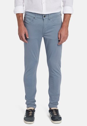 Lichtblauwe katoenen pantalons met een slim fit, voorkwestern en een knoopsluiting. Gecombineerd met donkere sneakers met witte accenten.