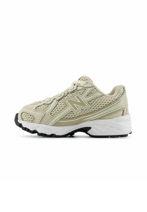 Scarpa da corsa New Balance beige in mesh e sintetico con suola bianca ammortizzata e battistrada nero, vista laterale su sfondo bianco.