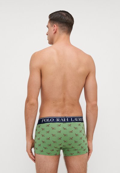 Zelene bokserice s igraćim uzorkom pasa, s tamnoplavim pojasom na kojem piše "POLO RALPH LAUREN" i prilagođenim dizajnom.