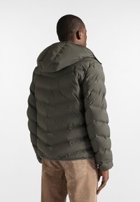 Chaqueta acolchada verde oliva con capucha, presenta un diseño de acolchado vertical, cremallera resistente y puños elásticos para mayor calidez.