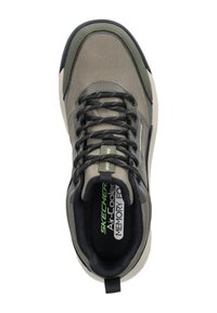 Zapatilla Skechers en verde oliva y gris, con una parte superior de tela texturada, cordones negros y una suela acolchada con la marca en la plantilla.