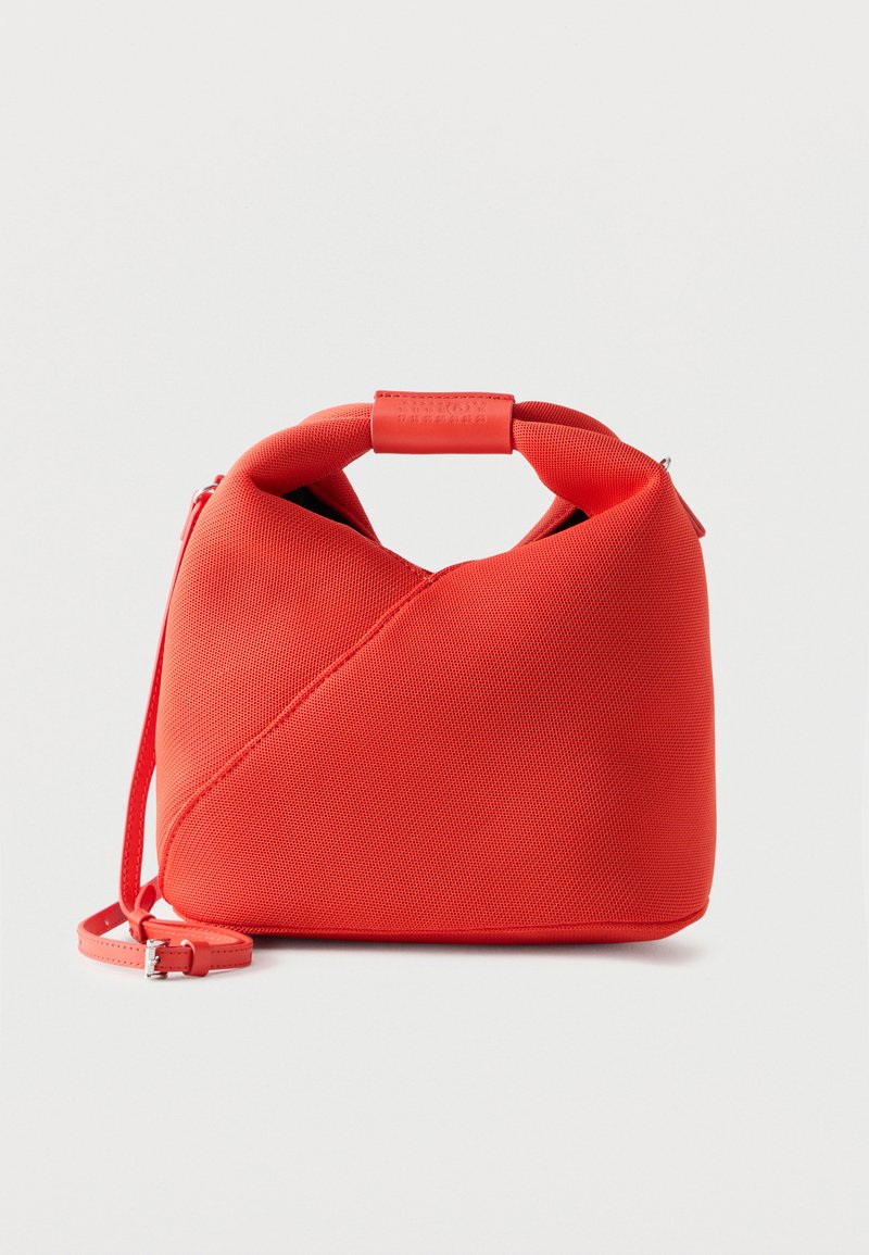 Sac à main en tissu rouge texturé avec une silhouette courbe, une poignée courte et une bandoulière réglable détachable sur un fond uni.