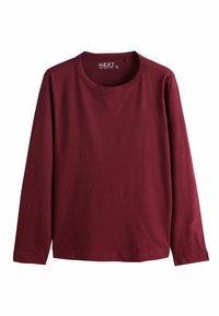 Sarkans krekls ar garām piedurknēm, izgatavots no gludas kokvilnas. Tam ir apaļa dekoltē un taisna apakšmala. Vienkāršs, vienkrāsains bez rakstiem.