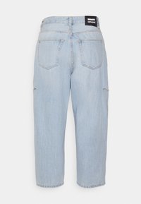 Jeans de denim azul claro com um corte relaxado, apresentando uma cintura alta, quatro bolsos e discretos detalhes de desgaste na parte da frente.