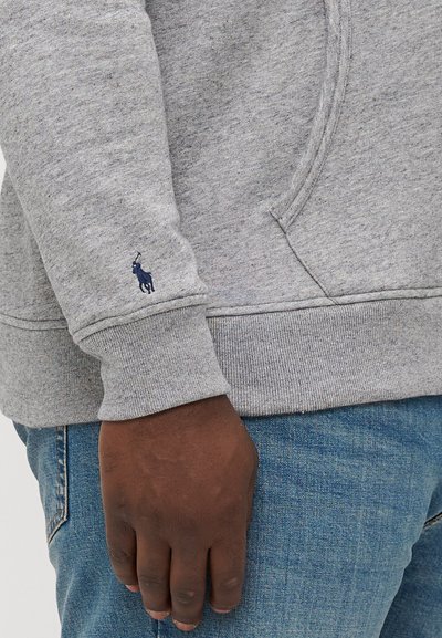 Szürke pulóver bordás mandzsettával és aljjal, a jobb ujjon, puha pamut keverékből készült, sötétkék hímzett logóval.