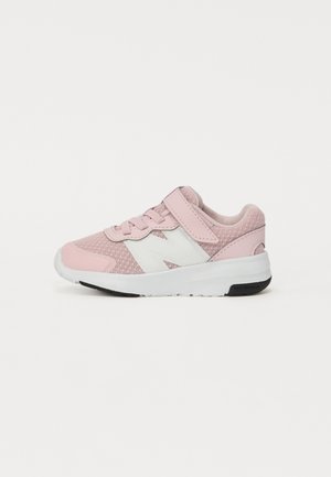 Zapatilla deportiva rosa hecha de malla y material sintético con una correa de velcro, acento de logo blanco y suela de goma negra.