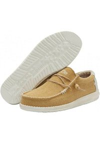Scarpe in tessuto intrecciato color sabbia con punta rotonda, suola in gomma bianca e lacci minimalisti. Presentano una superficie testurizzata e accenti naturali.