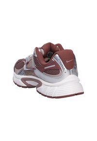 Běžecká obuv Nike s maroon síťovinovým svrškem, stříbrnými akcenty, polstrovanou bílou mezipodešví a strukturovanou gumovou podrážkou.