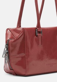 Borsa a tracolla rossa in pelle con finitura lucida, forma rettangolare, chiusura a zip e due manici. Presenta dettagli di cucitura sottili.