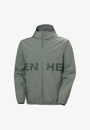 Chaqueta gris claro con capucha y cremallera, puños elásticos y texto verde oscuro parcialmente visible en el pecho.