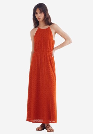 Maxi dress in bright orange, made of textured fabric with a geometric pattern. Features a halter neckline and a fitted waist.