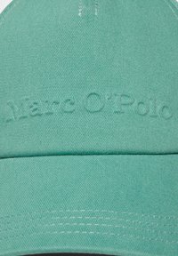 Lichtgroene baseballcap van textuurstof. Bevat het reliëf 'Marc O'Polo'-logo aan de voorkant en een gestructureerde rand met contrasterende stiksels.