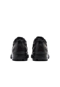Black athletic shoes featuring a mesh and synthetic upper, robust rubber sole, and padded collar, with a streamlined, modern design.