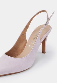 Chaussure à talon haut slingback en daim violet clair avec bout pointu et bride à boucle réglable sur fond blanc.