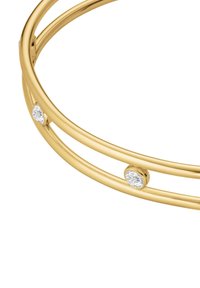Bracciale in oro con due bande che si intersecano, caratterizzato da tre piccole gemme rotonde di cristallo incastonate nel design. Finitura metallica liscia.