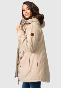 Beige parka jacket met capuchon, koordaccenten, rits aan de voorkant en twee zijzakken. Bevat een logo patch op de mouw.