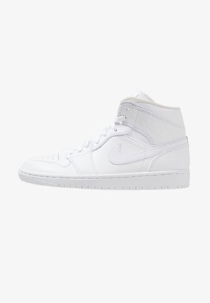 Białe skórzane trampki typu high-top z sznurowadłami, perforowanym noskiem, logo Nike po boku oraz wytłoczonym logo Air Jordan w pobliżu kołnierza przy kostce.