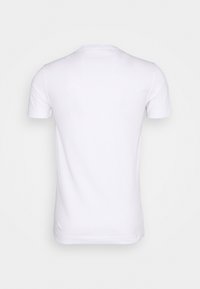 Camiseta de algodón blanca. Mangas cortas, cuello redondo, color sólido. Textura suave, diseño sencillo, sin patrones ni adornos visibles.