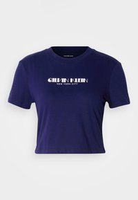 Tamsiai mėlyna Trumpa T marškiniai pagaminti iš medvilnės, su trumpomis rankovėmis ir apykakle. Priekinėje pusėje rašoma "CALVIN KLEIN NEW YORK CITY" balta spalva.