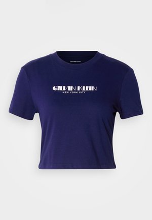 Námorně modré krátké tričko vyrobené z bavlny, s krátkými rukávy a kulatým výstřihem. Na přední straně je nápis "CALVIN KLEIN NEW YORK CITY" v bílém písmu.