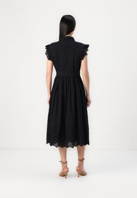 Melnas midi kleitas ar īsām volānu piedurknēm, pieguļošu augšdaļu, savilktu jostasvietu un izplestu svārku. Ziedu izšuvums ap apakšu.