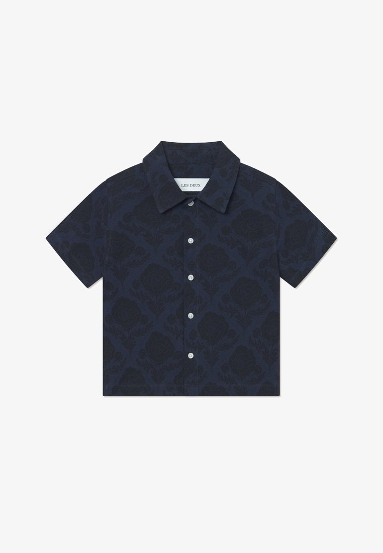 Chemise bleu marine à manches courtes avec un motif floral, fabriquée en tissu léger. Elle présente un col boutonné et une fermeture à boutons sur le devant.