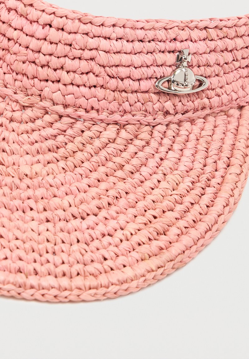 Visiera in paglia intrecciata rosa con logo metallico a forma di sfera argentata al centro davanti, su sfondo bianco.