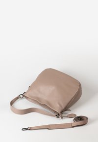 Beige Leder Schultertasche mit verstellbarem Schulterriemen und Metallverschlüssen, flach auf einer weißen Oberfläche liegend.