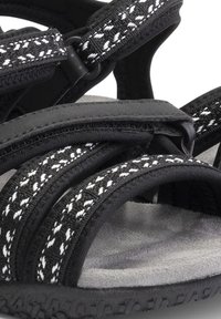 Zwarte en grijze sandalen zijn voorzien van textuurstofbanden met witte accenten, een gevoerd voetbed en een geribbeld rubberen zool voor grip.