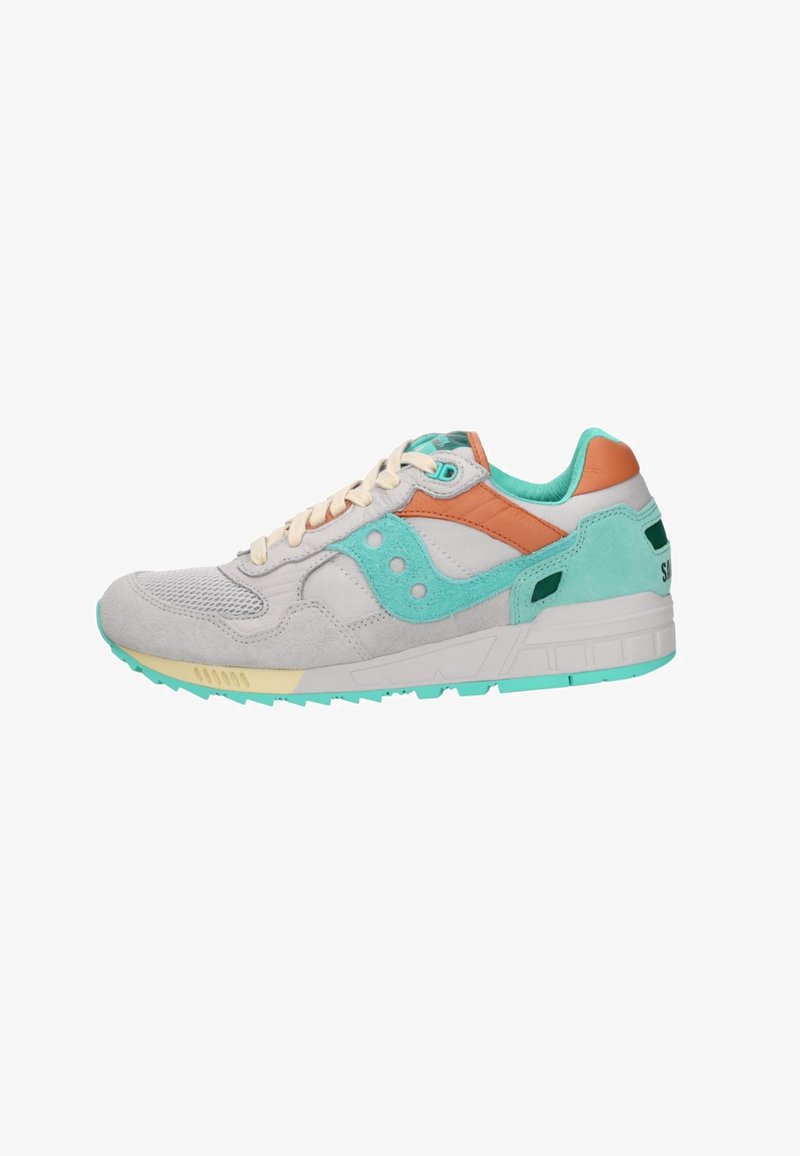 Lichtgrijze en turquoise sportieve sneaker met beige veters, oranje accenten en een getextureerde zool, zijaanzicht op een witte achtergrond.