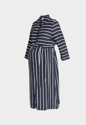 Marineblauwe jurk met witte horizontale strepen op het bovenstuk en verticale strepen op de rok, knoopsluiting aan de voorkant, lange mouwen en een ceintuur in de taille.
