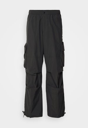 Pantalones cargo negros hechos de material ligero que cuentan con múltiples bolsillos laterales y puños ajustables. Cintura elástica para mayor comodidad.