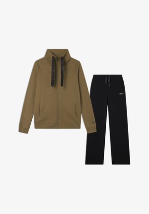 Giacca zip-up verde oliva con colletto alto e cordini neri, abbinata a pantaloni felpati neri con vita elastica e dettaglio con logo.