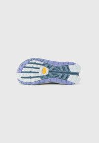 Sålen til en løpesko med lilla, blå og hvit mønster, med en gul Vibram-logo i sentrum.