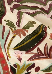 Patroonstof met grote, kleurrijke bladeren en bloemdesigns in tinten groen, roze, rood en blauw op een crèmekleurige achtergrond.