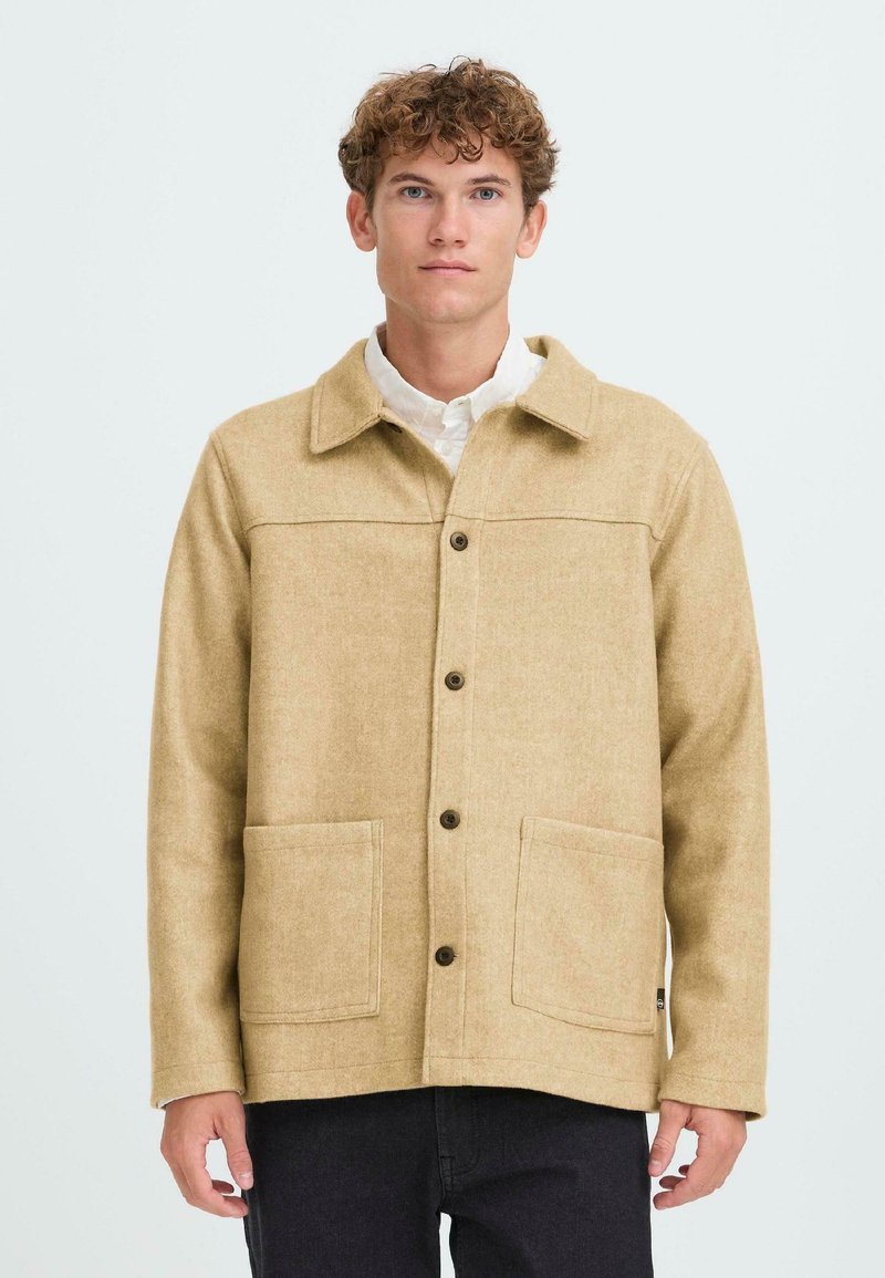 Beige wool blend jacket with a collar, front button closure, two large pockets, and tonal stitching. Fabric has a soft texture.
