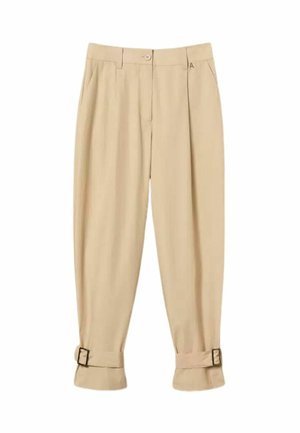 Pantaloni beige a vita alta con pieghe frontali, tasche laterali, chiusura con bottone, passanti per cintura e cinturini regolabili con fibbia ai polsini delle caviglie.