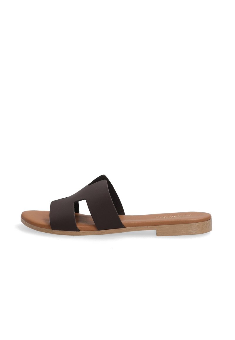 Brune slidesandal med to overlapping remme, lavet af blødt materiale. Flad sål med lysfarvet tekstureret bund, minimalistisk design.