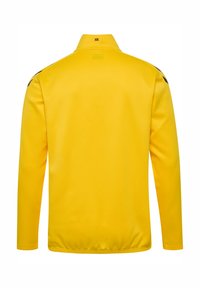 Gul långärmad jacka med hög krage, med svarta detaljer på axlarna och en solid textur. Bakvy, utan grafiska detaljer.