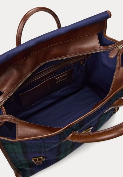 Borsa aperta in tessuto scozzese blu e verde con rifiniture in pelle marrone, che mostra un ampio interno blu navy, tasca con zip e due manici.