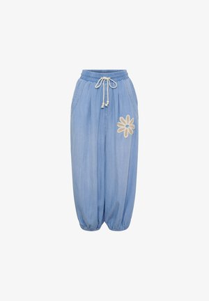 Lyseblå, løstsiddende bukser med elastisk linning, snøre, elastiske manchetter og hvid blomsterpålægning på højre lår.