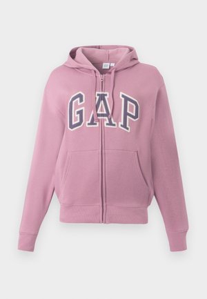 Felpa rosa con zip e logo "GAP" in bianco e blu navy. Presenta un cappuccio, tasche frontali e polsi a coste. Realizzata in morbido tessuto misto cotone.