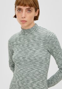 Długi rękaw top w strukturalnym zielonym materiale z podwyższonym kołnierzem. Posiada subtelny wzór, dopasowany krój i miękkie wykończenie.