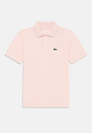 Polo majica od mekanog pamučnog materijala u svijetlo ružičastoj boji, s klasičnom ovratom, tri gumba na prednjem dijelu i zelenim izvezenim krokodilom na lijevoj strani prsa.