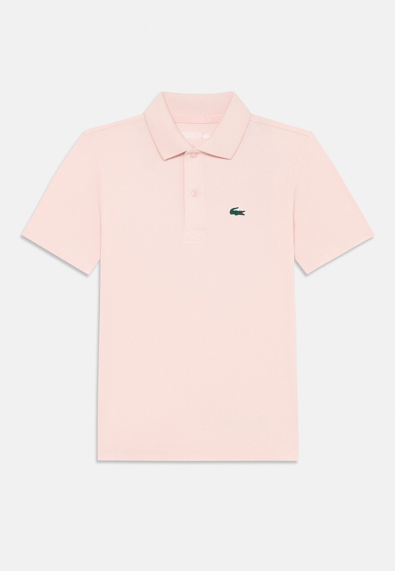 Polo em algodão rosa claro com colarinho clássico, pala com três botões e um logo de crocodilo bordado em verde no lado esquerdo do peito.