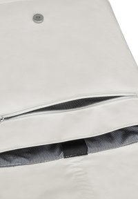 Világos színű vászontáska cipzáras zsebbel és csíkos bélésborítással. Jellemzője egy fémből készült snap zár, valamint textúrált anyag.