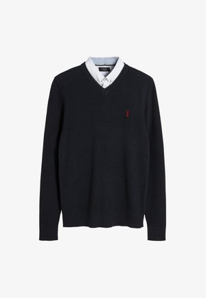 Marineblauer Strickpullover mit V-Ausschnitt und langen Ärmeln, darunter ein weißes Hemd mit Kragen und einem kleinen roten Hummer-Logo.