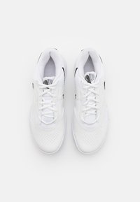 Pantofi sport albi cu material din plasă, laturi perforate, șireturi plate și accente negre pe laterale. Vârful rotunjit și talpa amortizată.