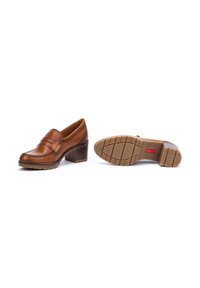 Brown leather heeled loafers with a round toe, detailed strap across the vamp, and a textured rubber outsole for grip.